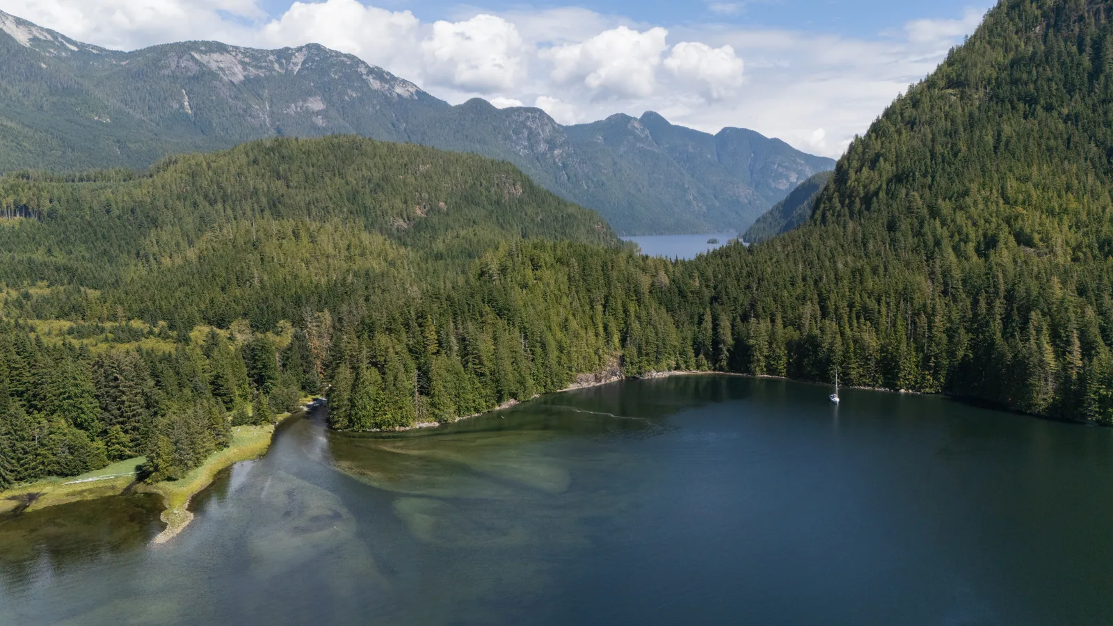 Luftaufnahme eines Kanals zwischen bewaldeten Bergen in den Discovery Islands